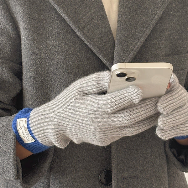 グレーの手袋を着けたまま指先を出してスマートフォンを操作する様子